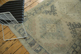 Distressed end of a vintage Oushak runner with intricate blue and beige border.
