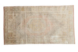 Distressed vintage Oushak rug with octagonal geometric medallion in pale blush, gold, and ivory.