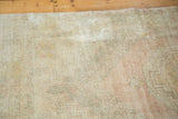Faded blush, dusty gold, and ivory patterns on distressed vintage Oushak rug.