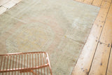 Distressed texture with muted geometric motifs in pale blush and dusty gold tones.