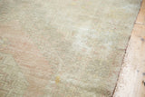 Distressed pile texture of the Oushak rug, with faded pale blush and antique ivory tones.