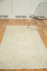 Distressed Oushak runner corner with faded curvilinear motifs and soft fringes.