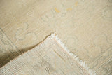 Distressed Oushak rug pile, showing even wear, ivory fringe, and hand-knotted foundation.