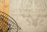 Distressed vintage Oushak runner, showing textured pile with dusty green and ivory motifs.