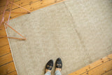 Faded Mir Boteh pattern and distressed texture of the vintage Oushak rug's muted tones.