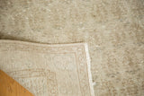 Distressed ivory, gray, and beige pile showing hand-knotted foundation of vintage Oushak rug.