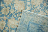 Distressed Tabriz carpet, showing worn sky blue and dusty gold pile, plus foundation and fringe.