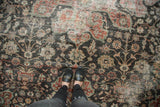Distressed vintage Mahal carpet with worn pile, scrolling vinery in charcoal, red, green tones.