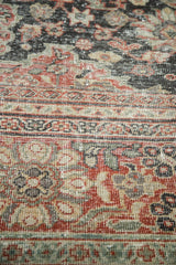Distressed Mahal carpet's worn pile texture, with madder red, charcoal, and sea foam floral patterns.