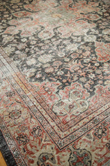Distressed Mahal carpet corner, displaying faded charcoal, madder red, and ivory scrolling vinery.