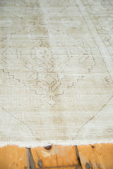 Distressed vintage Oushak runner texture with muted beige-ivory geometric motifs.