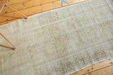 Central geometric medallion of a distressed vintage Oushak runner, with ivory, beige, and faded charcoal patina.