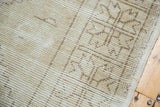 Distressed vintage Oushak rug pile showing muted beige tones and subtle geometric pattern.
