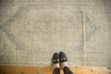 Distressed pile texture with stepped geometric medallion and muted silver, ivory, beige tones.