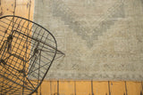 Distressed vintage Oushak runner's blanket-stitched edge with fringe and muted geometric pattern.