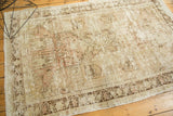 Distressed vintage Oushak rug's chocolate brown border and pictorial field with foundation visible.