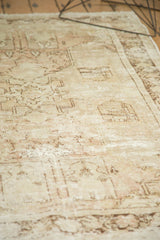 Textural distressed pile of the vintage Oushak rug, showing faded ivory and blush patterns.