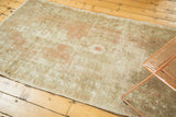Distressed vintage Oushak rug runner's worn pile texture and muted blush, beige geometric pattern.