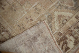 Vintage distressed Oushak rug corner, showing pile wear, exposed foundation, and fringe.
