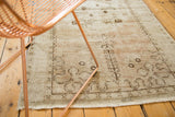 Distressed Oushak runner's low pile texture with faded beige, blush, brown geometric patterns.