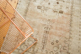 Distressed vintage Oushak rug with low pile texture, faded blush and beige patterns.