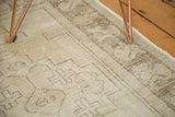 Textural geometric patterns in pale beige and faded brown on the distressed Oushak rug.