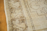 Distressed vintage Oushak runner close-up, highlighting geometric pattern, low pile, and secured edge.