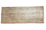 Distressed vintage Oushak runner with triple medallions, quatrefoil relief in muted beige and brown tones.