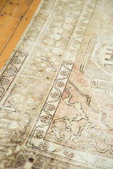 Distressed Oushak rug with faded beige, mauve, and chocolate brown patterns, revealing pile wear.