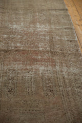 Distressed Oushak runner pile showing worn texture and faded sand, blush colors.