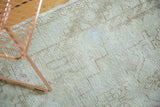 Distressed texture of vintage Oushak runner, showing ivory field and a light gray blemish.