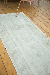 Distressed Oushak rug runner showcasing faded ivory and pale charcoal rectilinear patterns.