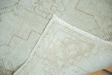 Hand-knotted foundation, distressed ivory pile with rectilinear patterns, and short fringe of a vintage Oushak rug.