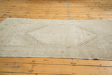 Distressed texture of a vintage Oushak rug, showing muted geometric patterns.