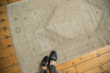 Vintage distressed Oushak rug corner with faded geometric spandrel and textural pile.