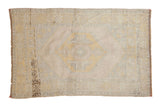 Distressed Oushak rug, faded hexagonal medallion, pale beige, dusty saffron yellow, soft blue.