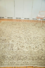 Curvilinear floral and vinery patterns on distressed vintage Meshed rug with time-softened tones.