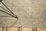 Distressed Oushak rug texture showing even wear, soft beige, pale sand, and fringe.
