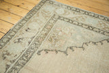 Distressed Oushak rug pile revealing faded beige, soft pink, and charcoal border details.