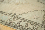 Distressed Oushak carpet border with scalloped contouring, showing muted charcoal and pale coffee patterns.