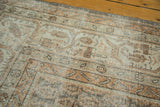 Vintage distressed Oushak rug corner showing vinery, silver, ivory, and terra cotta tones.