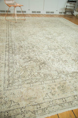 Distressed Oushak rug showing muted ivory, beige, charcoal floral arabesques and vinery.