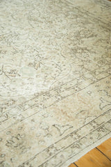 Evenly worn distressed vintage Oushak rug with sprawling vinery and tendrils in ivory and charcoal brown.