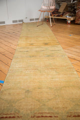 Distressed Pak Bokhara runner texture, showcasing fantastic abrash and subtle gul motifs in gold and pale green.