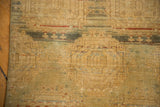 Distressed Pak Bokhara runner close-up: abrash, faded golden guls, green, and secured side visible.