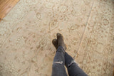 Evenly distressed pile of Oushak carpet, featuring pale lotus and tendril motifs.