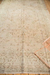 Evenly distressed Oushak carpet with faded beige blush and coffee lotus patterns.