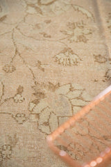Distressed texture of Oushak rug, revealing pale dusty beige lotus and tendril motifs.