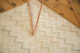 Distressed Oushak rug's vertical zig-zag channels with even pile wear and pastel tones.