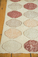 Distressed vintage Oushak rug's decorative repeating circles in faded ivory, apricot, and coffee tones.